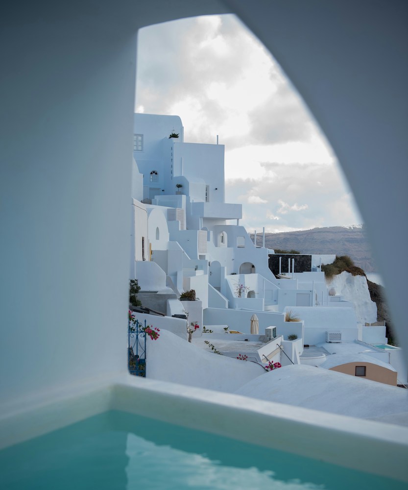 Woman in an infinity pool looking out to a beach